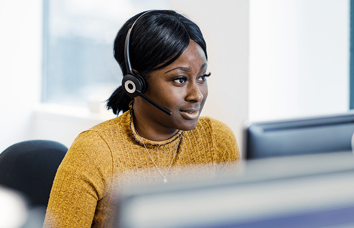 Lächelnde TOPdesk Support-Mitarbeiter mit Headset.