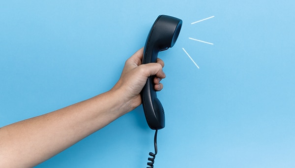 Hand, die ein Telefon hält.
